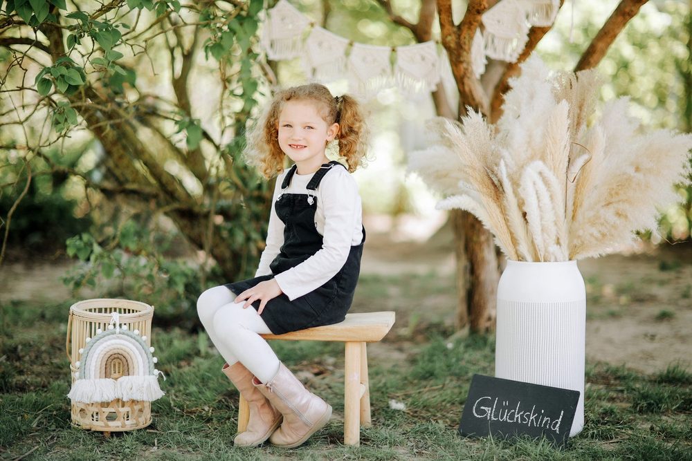 Mädchen auf dem Hocker im Boho-Set beim Kita-Fototag