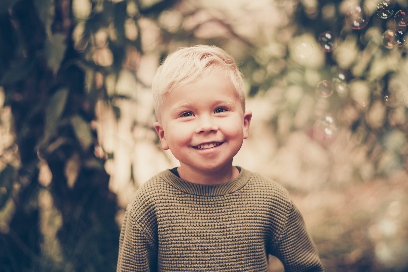 Fröhliches Kinderporträt mit Seifenblasen im Herbstlicht