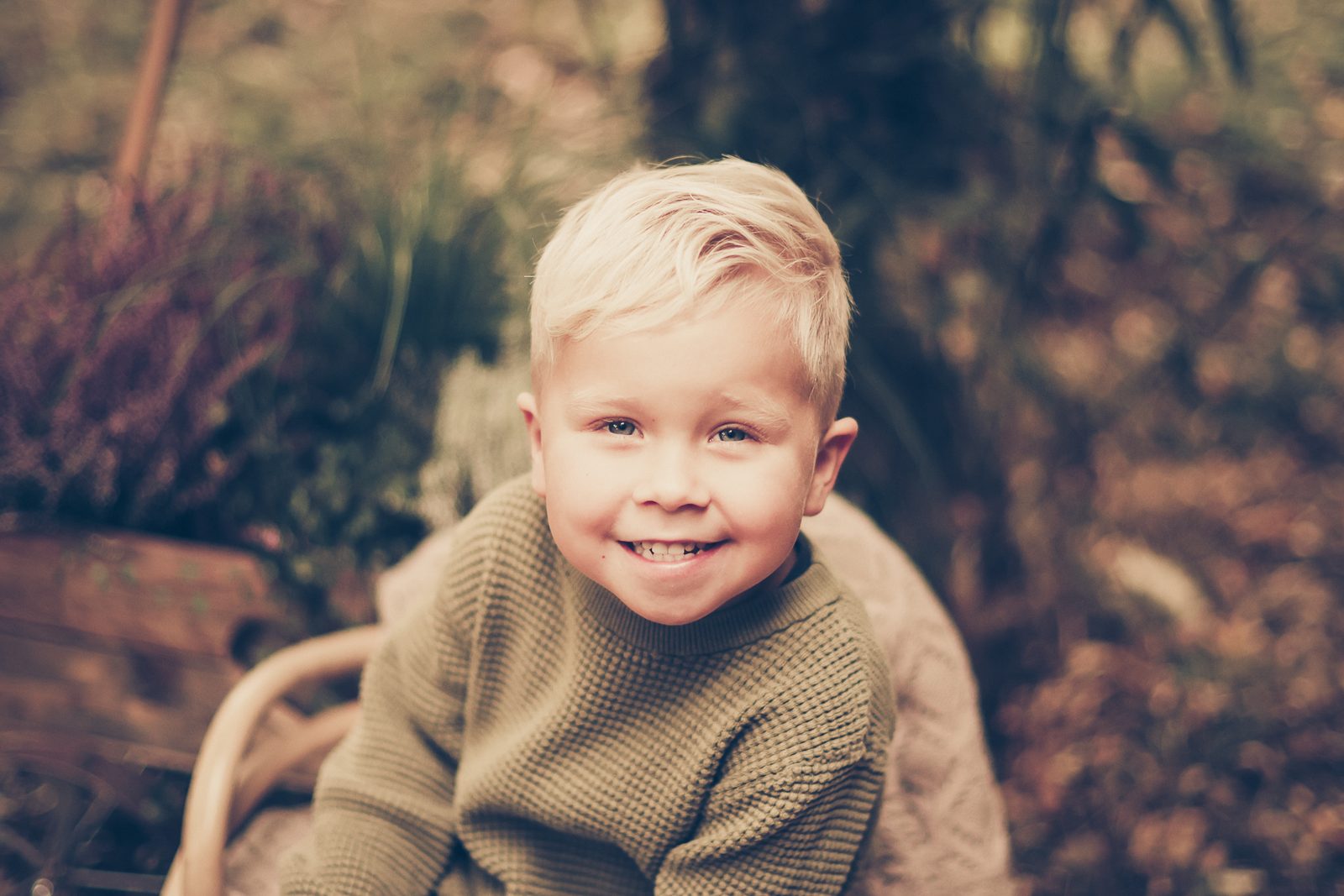 Nahes Porträt eines lächelnden Jungen im Herbstlicht