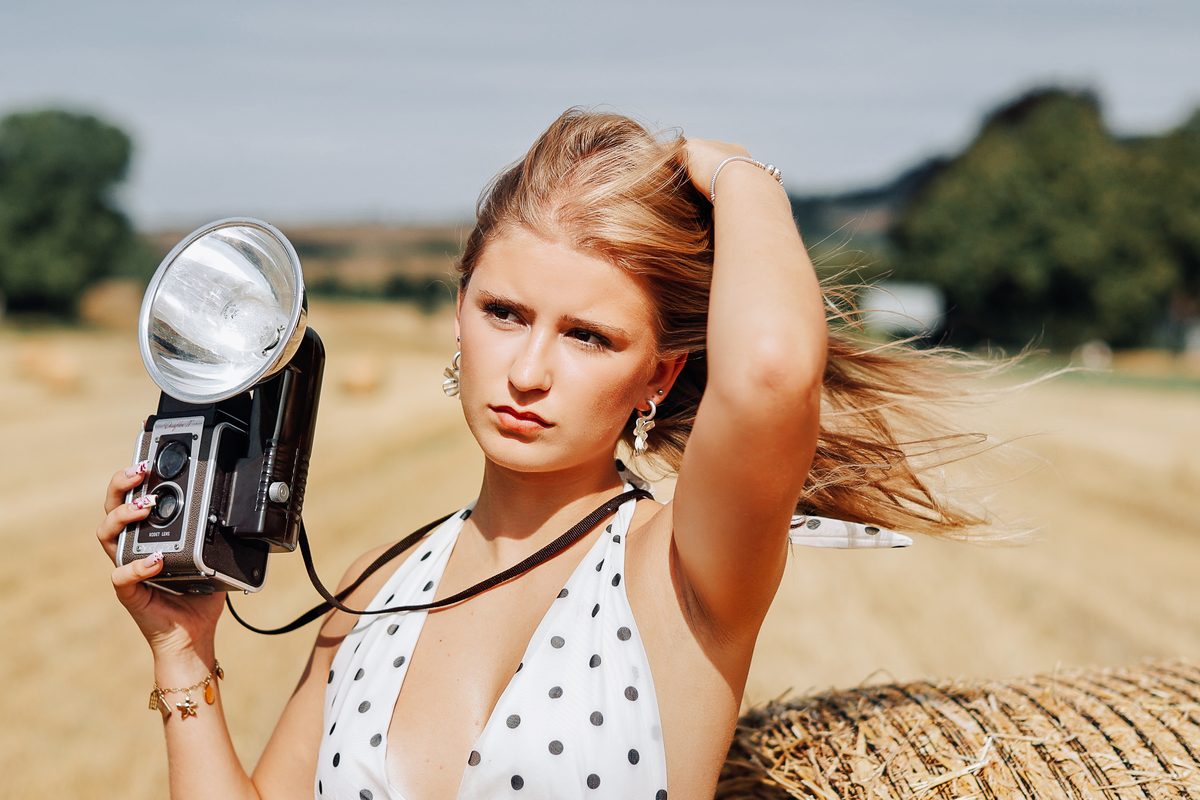 Portrait mit alter Kamera im Stoppelfeld – Airy