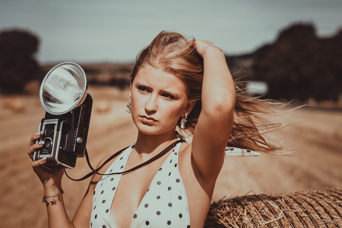 Portrait mit alter Kamera im Stoppelfeld – Moody